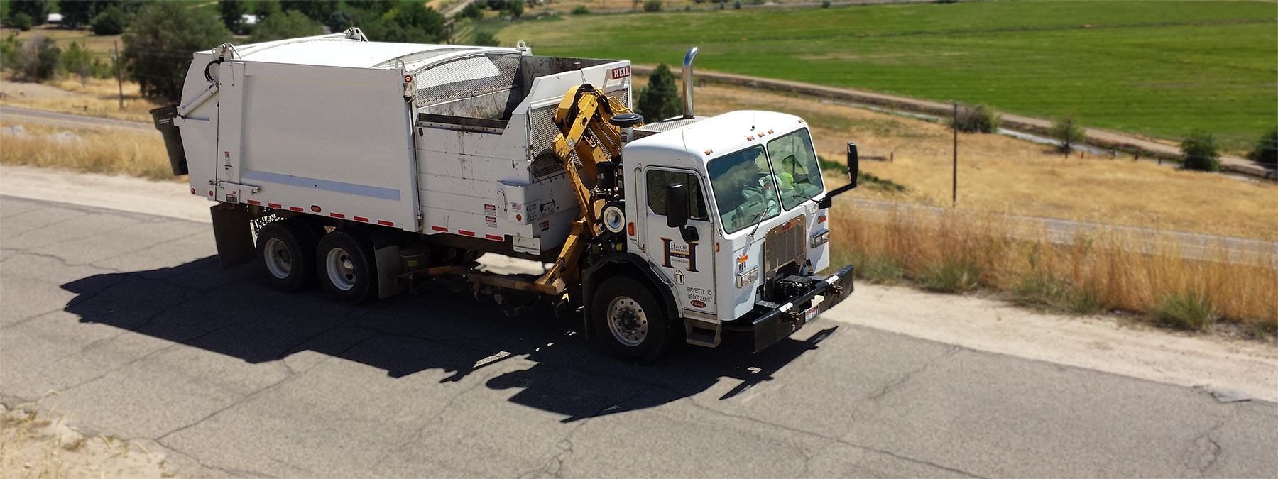 Photo of a Hardin Sanitation Truck driving down a road.